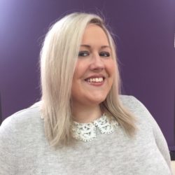 headshot of Lynn who has blonde hair and is wearing a grey top with embroidered collar