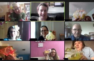 Group of 9 people holding up craft items they have created