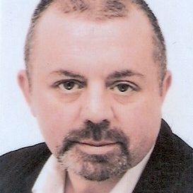 Portrait of Iain Montgomery, GDA's Vice Convenor - Iain has very short dark grey hair and goatee, and is wearing dark jacket and white shirt.