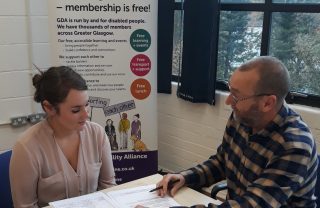 GDA staff member Brian Scott gives one to one advice to a young person, looking over paperwork on a table