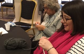 Two members knit, side by side