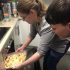 With support, a visually impaired member puts a meal they have made in an oven.