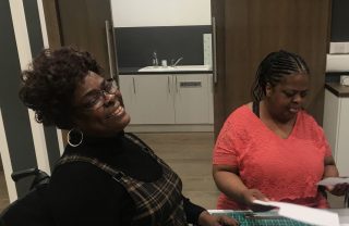 One member is laughing while taking part in a craft workshop