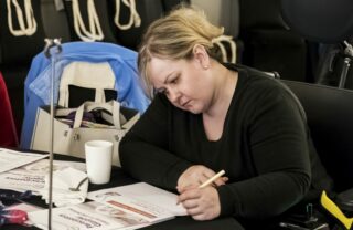 A member fills out a GDA form at a large event.