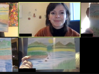 Picture shows woman with dark hair smiling, surrounded by pictures that people have drawn.