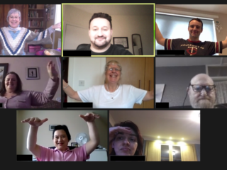 Picture of people holding their arms in the arm in a Tai Chi pose.