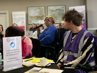 GDA member holds a mic at a GDA meeting